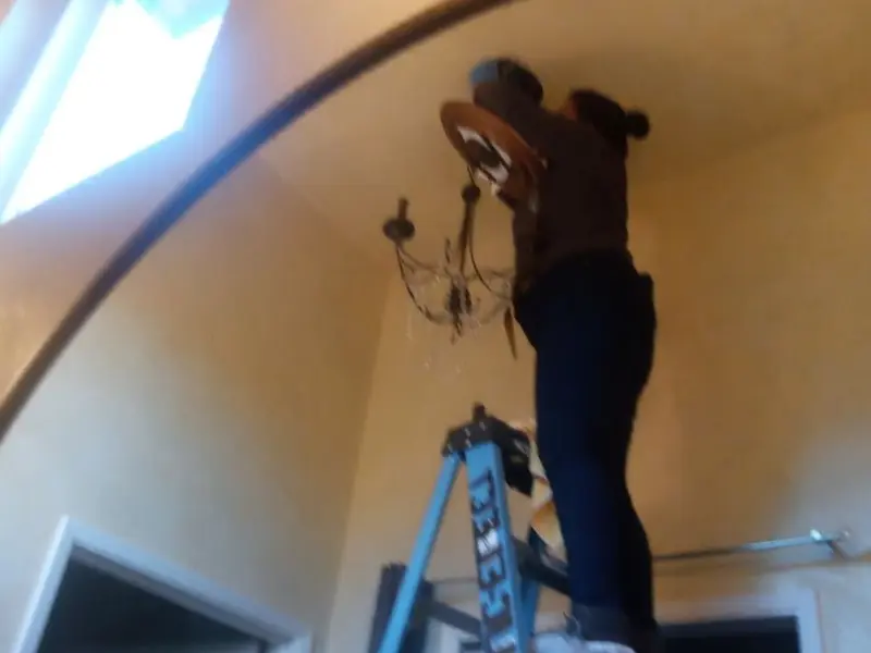 Electrician installing a chandelier in a Roseburg North residence